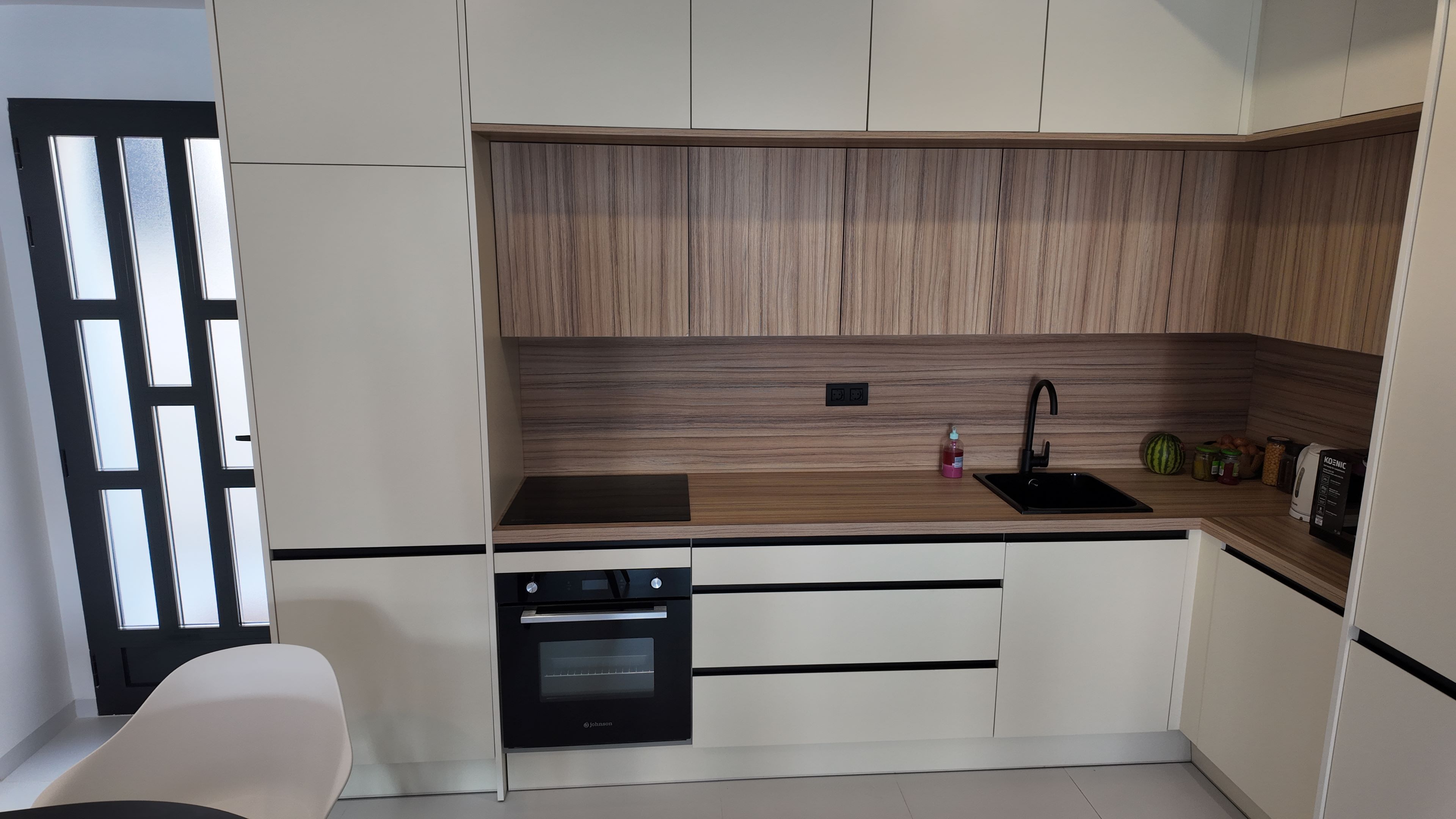 Keukenblok met houtlook kastjes, zwarte kraan en oven