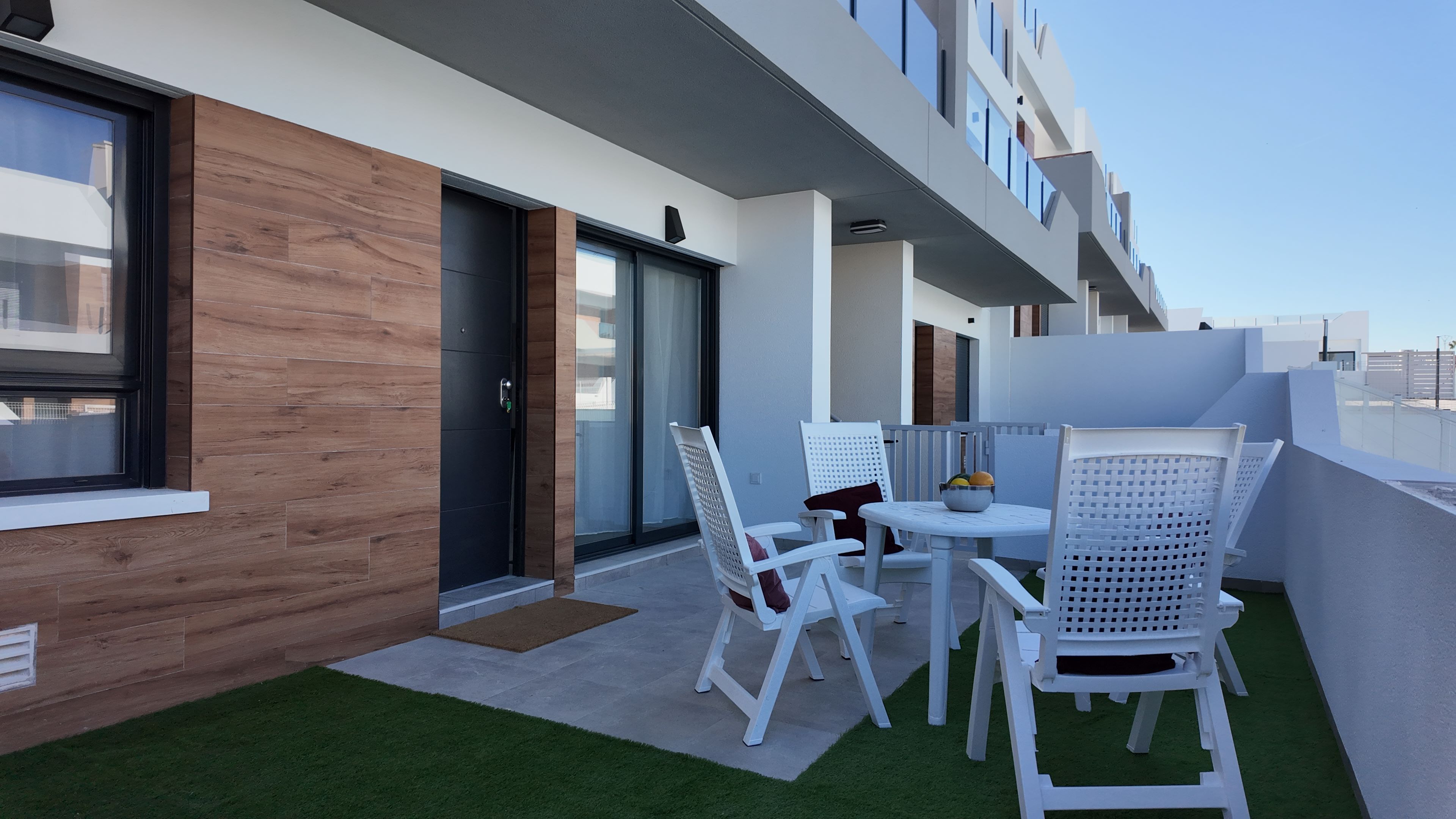Terras met witte tuinstoelen en tafel